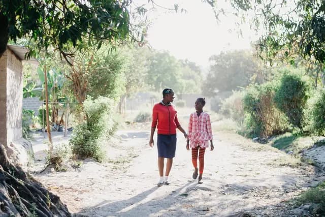 Woman and child walking on dirt path