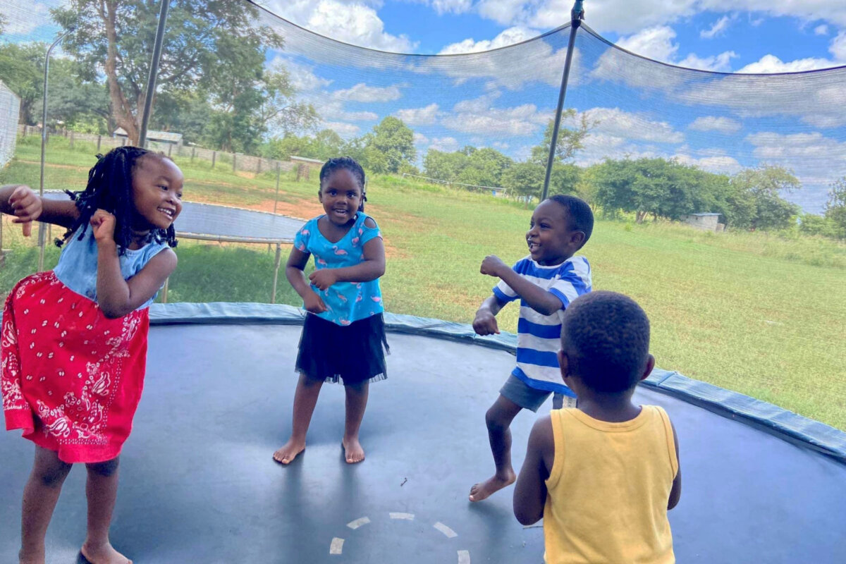 Orphaned and vulnerable children at New Day care play on a trampoline